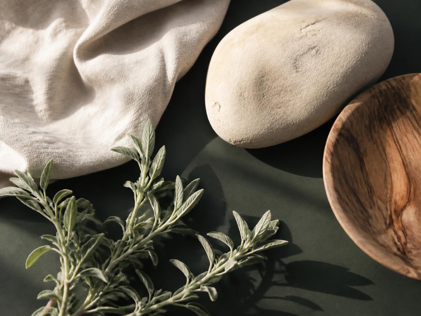Natural linen, stone, wood, and coastal sage in morning light